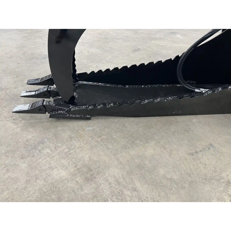 Black skid steer grapple bucket attachment with serrated curved arm, three flat digging teeth, and hydraulic hose on concrete floor