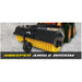 Black skid steer angle broom attachment with yellow rotating bristles on concrete surface near equipment tires