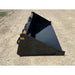 Black steel skid steer material bucket with smooth interior and yellow USA label on gravel surface