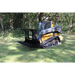 Compact track loader with black open rock grapple attachment and Deere branding on a grassy clearing near trees