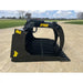 Black steel rock grapple attachment with spaced flat tines, hydraulic pivot arm, and yellow Stinger logo on gravel surface outdoors
