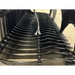 Interior view of black skid steer rock grapple attachment showing curved steel tines and hydraulic hose connections