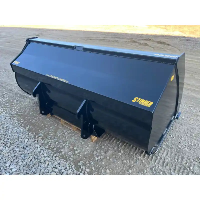 Back-right angled view of black steel construction material bucket with yellow Stinger branding on gravel surface