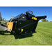 Side view of black tractor rock bucket reel attachment with yellow hitch on green grass under clear sky
