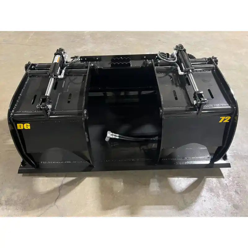 Black steel demolition grapple bucket attachment with dual hydraulic cylinders and hoses on concrete floor indoors