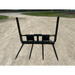 Black metal skid steer bale spear attachment with four pointed tines viewed from front on dirt surface