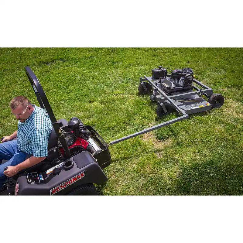 Operator seated on zero-turn mower towing Swisher 66-inch finish cut mower with 14.5HP Kawasaki engine, gallery position 1