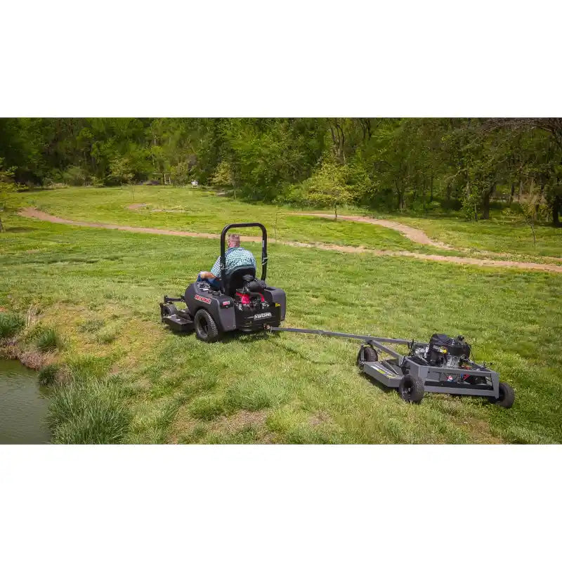 Swisher 66-inch finish cut mower attached to riding mower with tow-behind mower cutting grass, gallery position 1