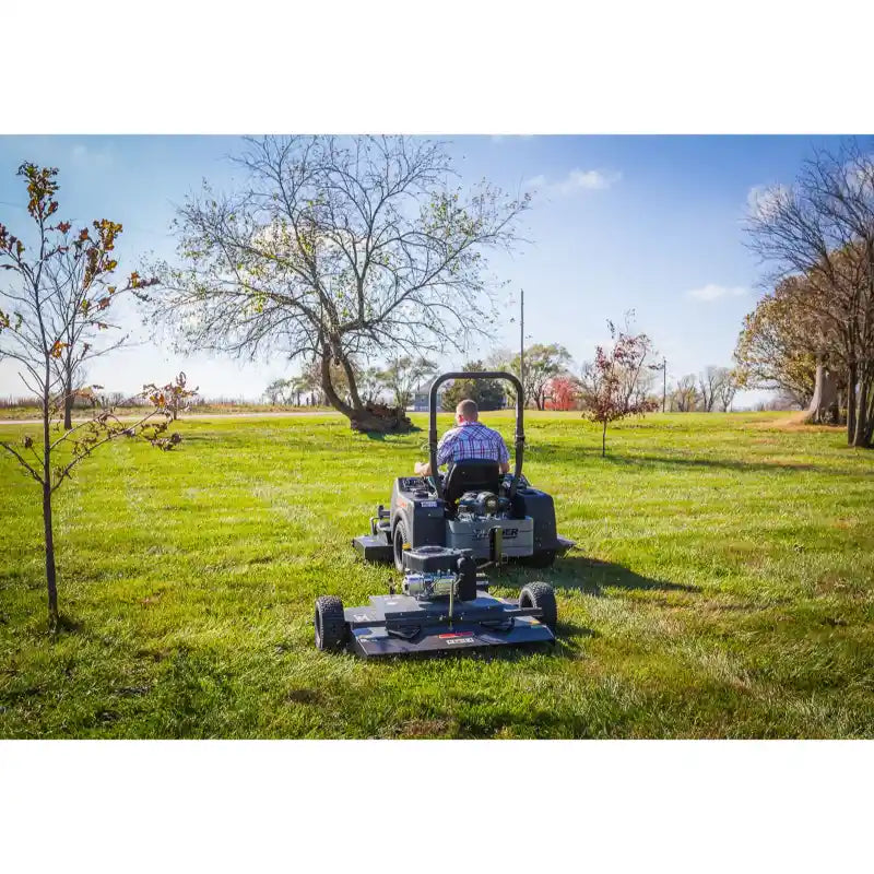 Rear view of a tractor towing a Swisher 44-inch finish mower over a large grassy field, gallery position 1