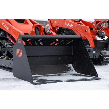 Black steel skid steer front loader bucket attachment with reinforced cutting edge and orange track loader in background