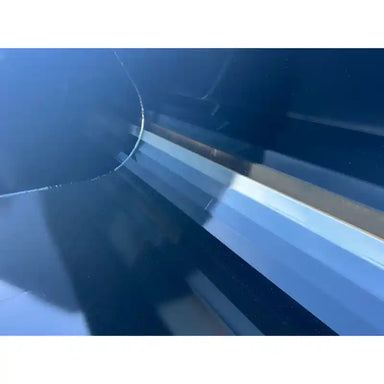 Close-up view of a smooth black steel skid steer bucket interior showing reinforced bottom edge