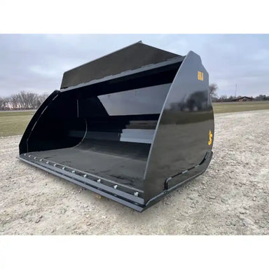 Front-right angled view of a black steel construction bucket attachment with reinforced cutting edge on gravel ground