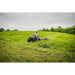 ATV pulling Swisher 44" rough cut brush mower across uneven grassy field, gallery position 1