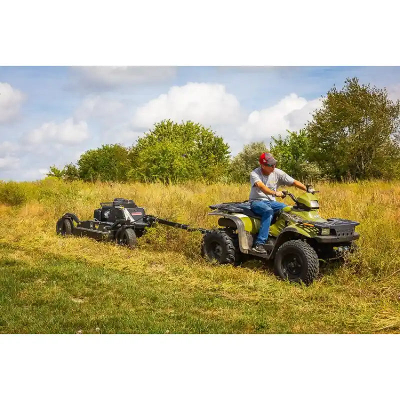 Operator on ATV towing Swisher 44-inch rough cut mower with Kawasaki 14.5HP engine across grassy field, gallery position 1