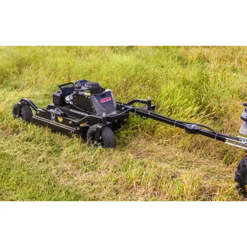 Tow-behind Swisher 44" brush cutter with 14.5HP Kawasaki engine cutting tall grass, gallery position 1