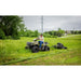 Man on ATV towing Swisher 44" rough cut mower across tall grass in rural setting, gallery position 1