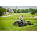 Operator riding ATV towing Swisher 44-inch rough cut mower cutting tall grass in residential area, gallery position 1