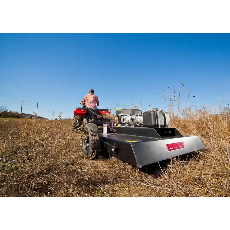 Swisher 44-inch Rough Cut Brush Cutter attached to ATV cutting thick brush, view from rear and right side, gallery position 1