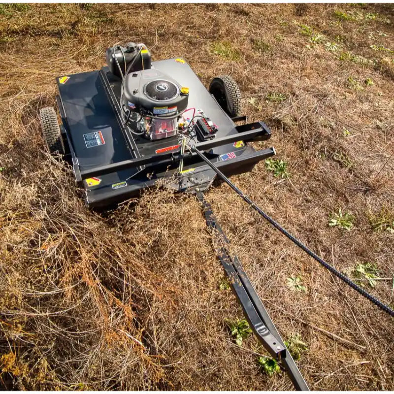 Swisher 44-inch rough cut brush cutter with 15.5HP engine and tow hitch, clearing brush, gallery position 1 view
