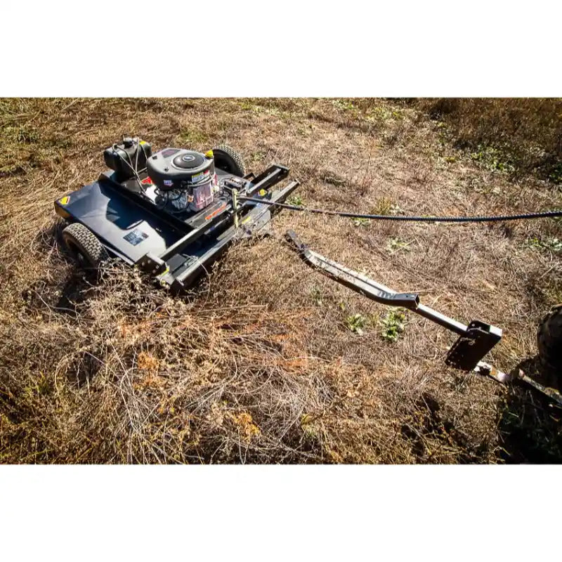 Swisher 44-inch rough cut brush cutter with 15.5HP engine attached via tow hitch, clearing dry brush, gallery position 1 view