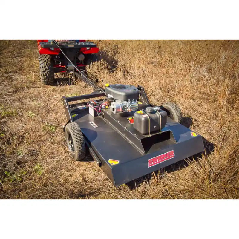 Swisher 44-inch rough cut brush cutter with 15.5HP engine attached to ATV, clearing dense dry grass, gallery position 1 view