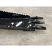 Black metal skid steer stump bucket attachment with three pointed digging teeth and serrated cutting edge on concrete floor