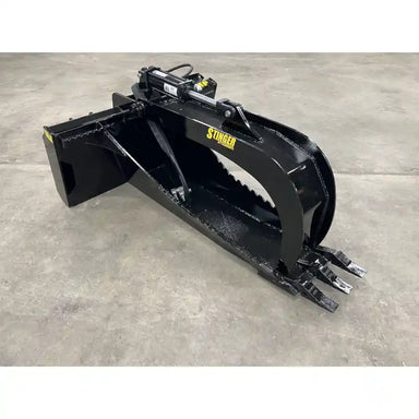 Black steel stump bucket with hydraulic grapple arms and serrated claws on concrete floor surface