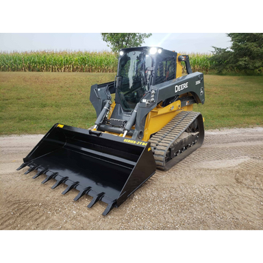 Yellow and black skid steer loader with tracked wheels and a toothed bucket attachment on compacted gravel pathway