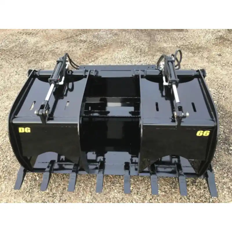 Black steel demolition grapple bucket with dual hydraulic cylinders and teeth resting on gravel surface outdoors