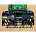 Black steel rock grapple attachment with wide spaced tines and dual hydraulic arms on grass field