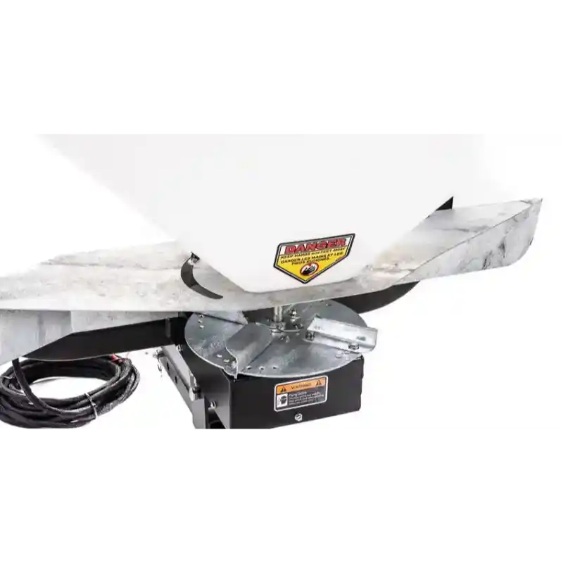 Close-up of spinner assembly and warning label underneath white hopper on Swisher Commercial Truck Spreader, gallery position 1