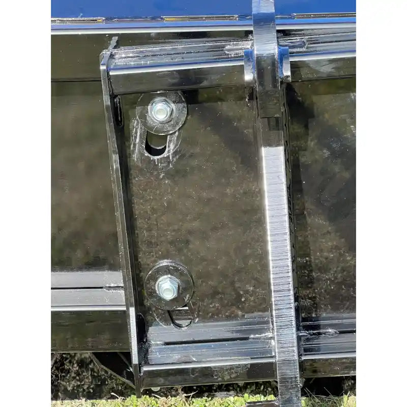 Close-up of black steel mounting bracket with bolts and welds on a metal frame attached to outdoor equipment