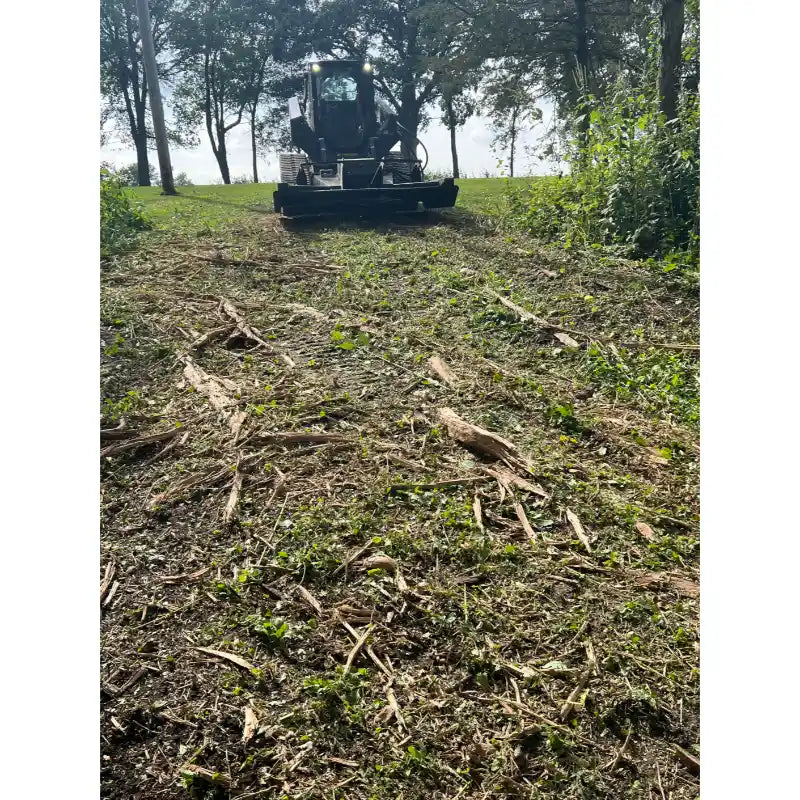 Skid steer with Stinger Attachments TF5 Twister brush cutter clearing brush and debris, forest background, gallery position 29.