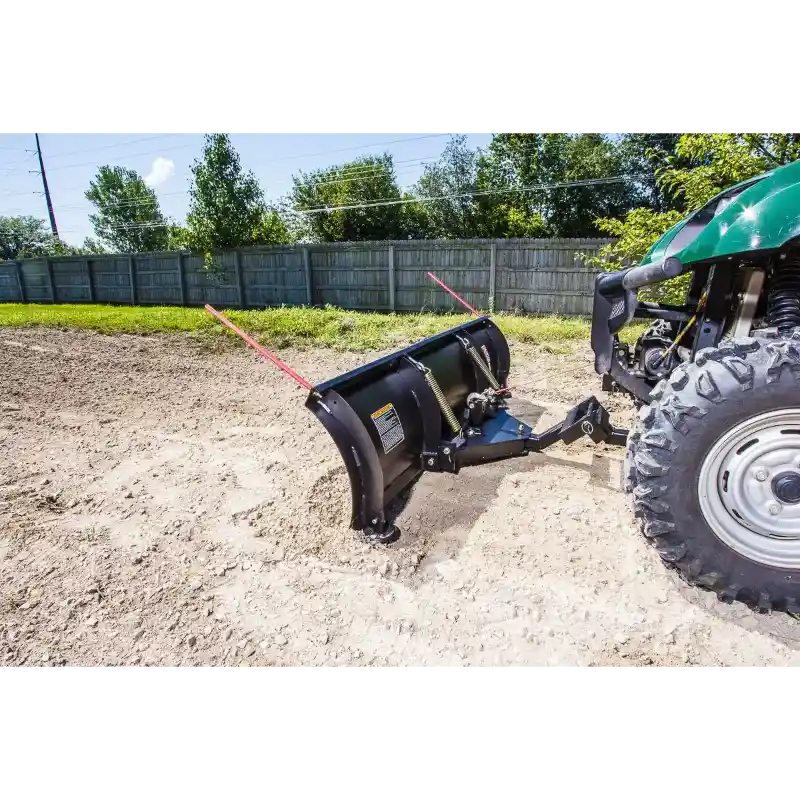 Green utility vehicle front-mounted with Swisher 62-inch plow rolled blade pushing soil, gallery position 1