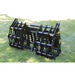 Black steel compact grapple attachment with reinforced bars and pivot points sitting on grass outdoors