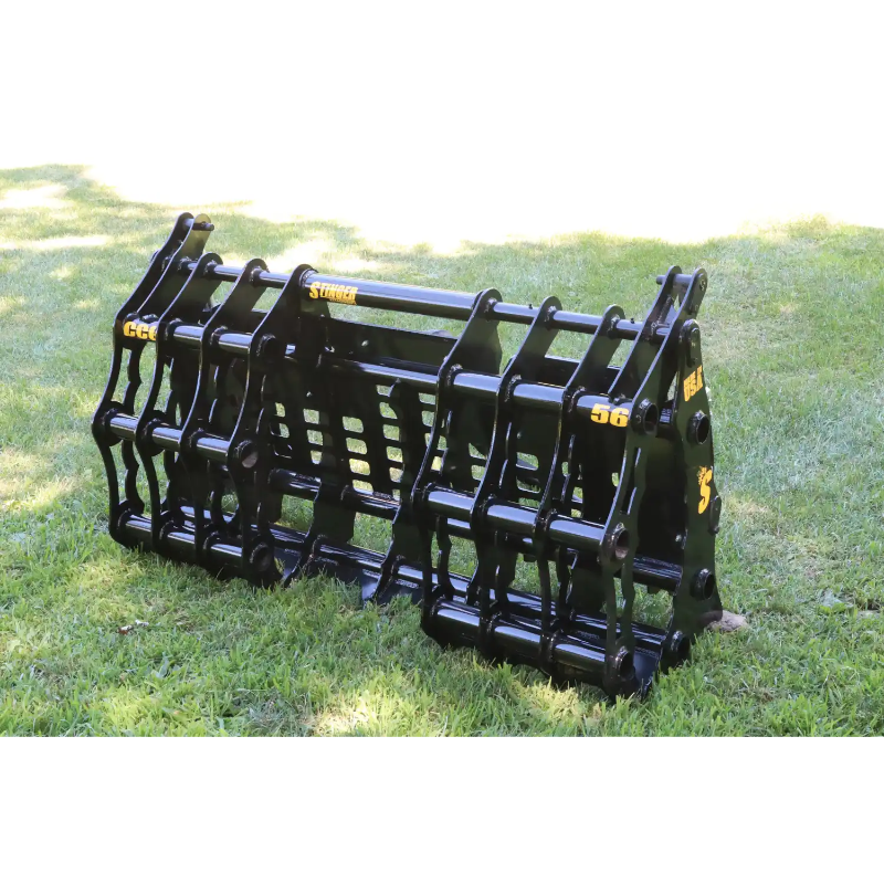 Black steel compact grapple attachment with reinforced bars and pivot points sitting on grass outdoors