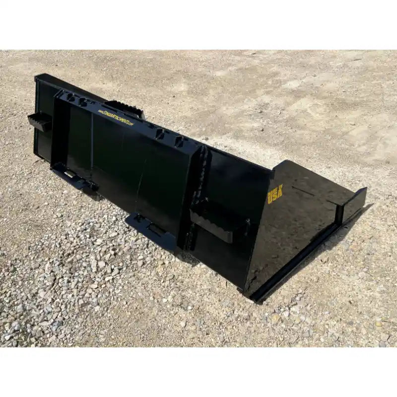 Black steel skid steer material bucket with reinforced side panels and mounting brackets on gravel surface outdoors