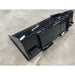 Black steel skid steer material bucket with rear step and reinforced mounting points on concrete floor indoors