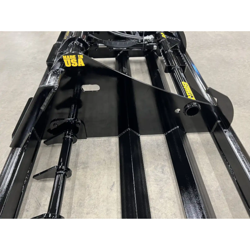 Close-up of black steel land plane skid steer attachment auger with welded blades and reinforced frame on concrete floor