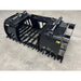 Black steel tractor root and rock grapple attachment with hydraulic cylinders, reinforced tines, and solid side panels on concrete floor