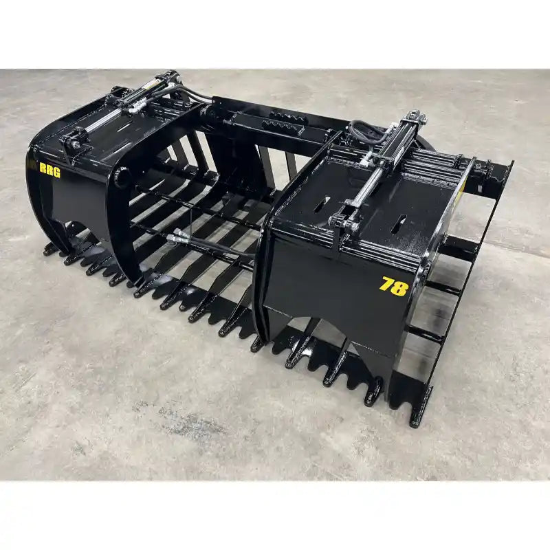 Black steel tractor root and rock grapple attachment with hydraulic cylinders, reinforced tines, and solid side panels on concrete floor