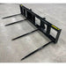 Black steel skid steer bale spear attachment with four long pointed tines viewed from left angle on concrete floor