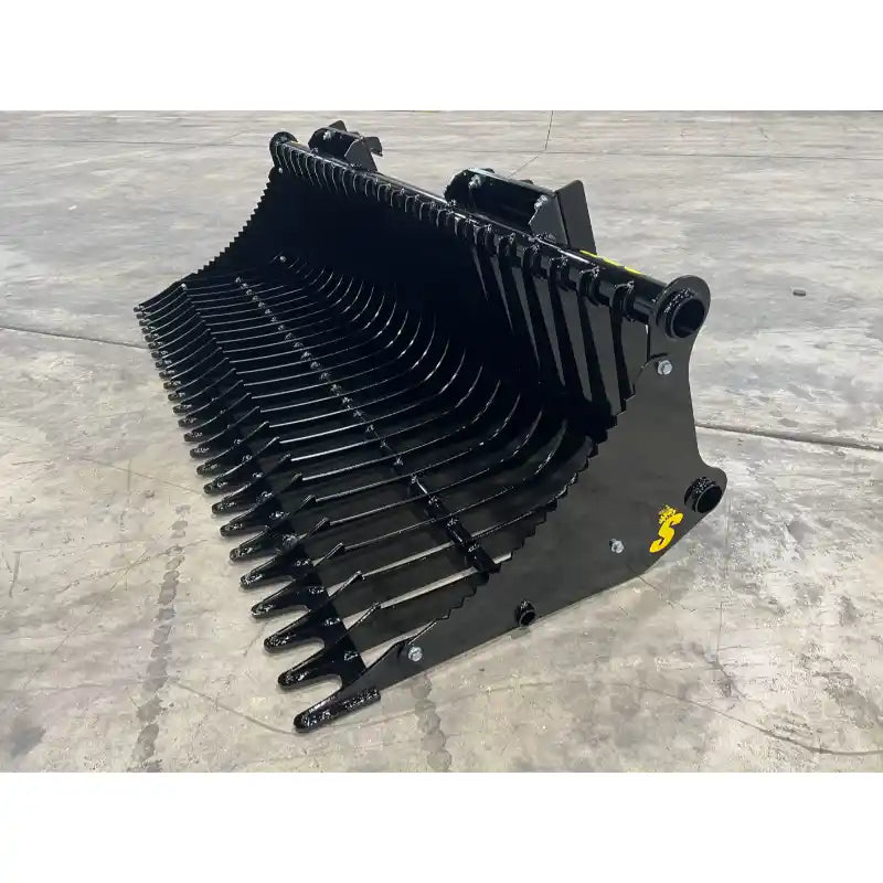 Black rock bucket skid steer attachment with spaced tines and reinforced side plates on concrete floor