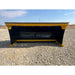Front view of black and yellow skid steer snow pusher attachment with reinforced cutting edge on gravel surface