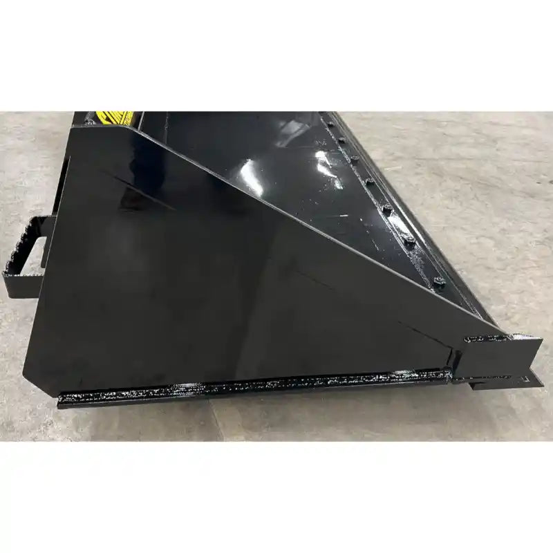 Black steel skid steer material bucket side with smooth panels and reinforced cutting edge on concrete surface