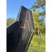 Close-up of Stinger Attachments TF5 Twister skid steer brush cutter deck edge against outdoor greenery background