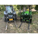Two black steel skid steer and tractor pallet fork attachments with grid backrests and extended forks on grass and dirt outdoors