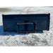 Rear view of black steel skid steer high-volume bucket attachment resting on gravel and light snow ground