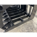 Black steel grapple attachment with spaced curved tines and reinforced welds on a concrete floor surface