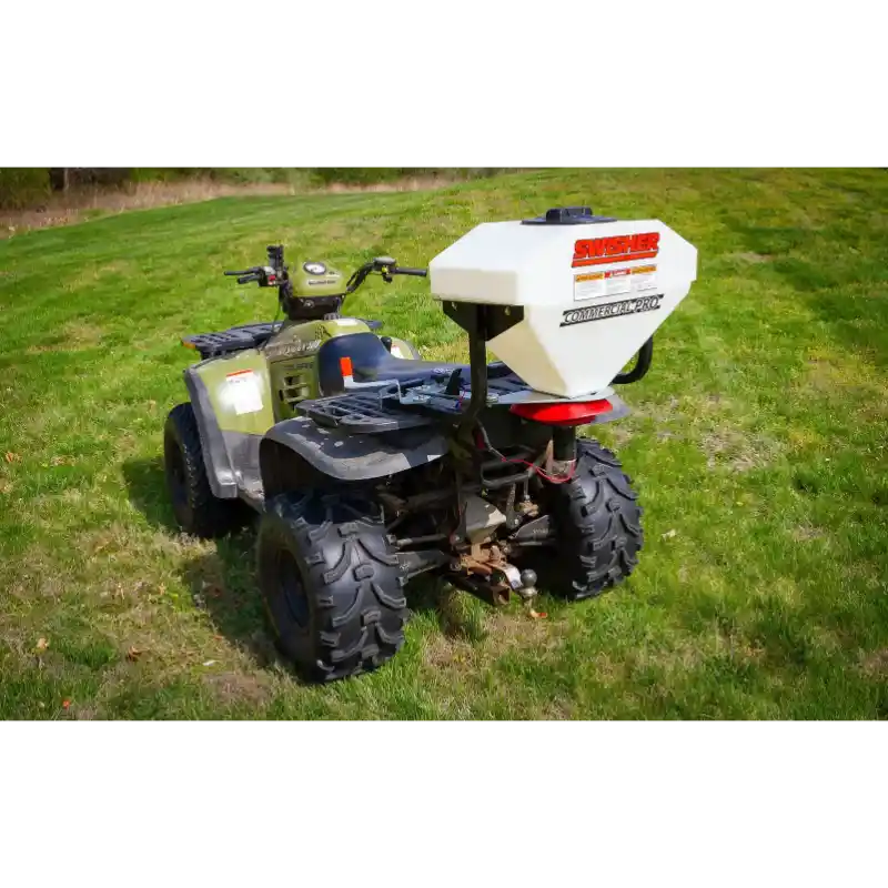 Swisher ATV Commercial Pro Spreader mounted on rear rack of green ATV on grass, gallery position 1